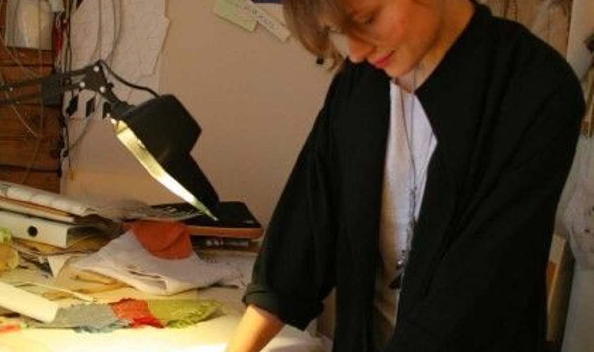 Kunstnik Kärt Ojavee näitab, kuidas soojustundliku värviga kaetud kangale ilmub peopesa kujutis. Foto: Alo Lõhmus