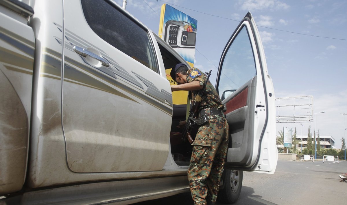 A police trooper checks a car at entrance of Sanaa International Airport