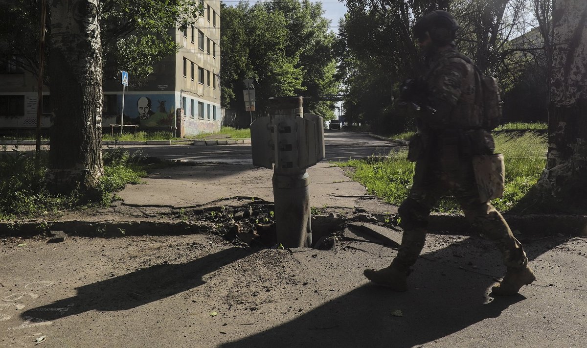 Украинский солдат проходит мимо остатков ракеты, упавшей неподалеку от Северодонецка