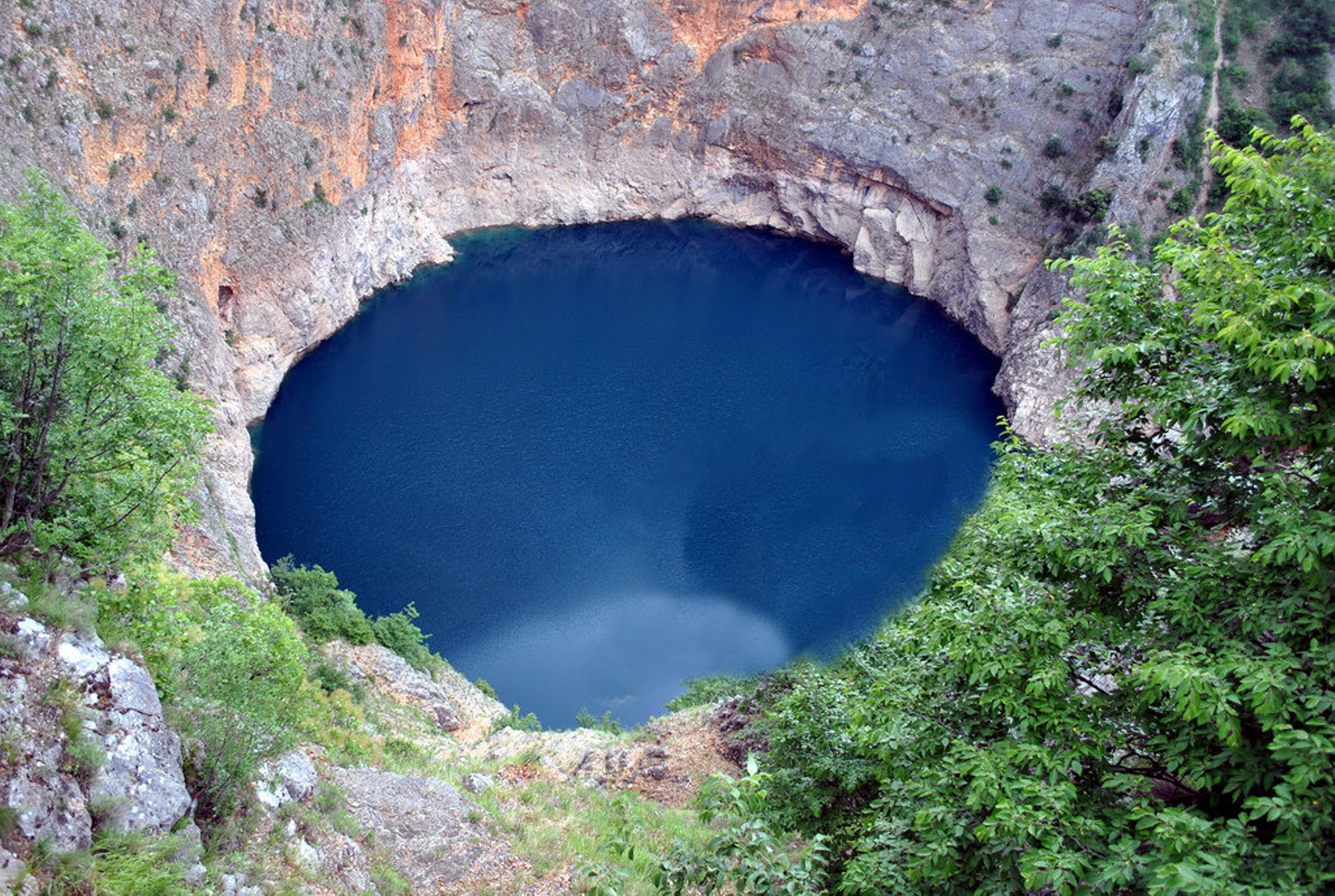 Озеро имеет глубину 20. Карстовая воронка в Хорватии. Голубое озеро Карст. Карстовая воронка с голубым озером. Карстовые озера Хорватии.