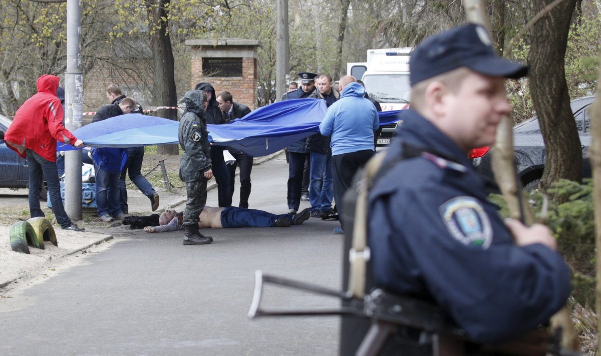 Investigators work near the body of journalist Oles Buzina in Kiev