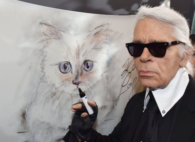 Карл Лагерфельд у портрета своей любимицы - кошки Шупетт на выставке в Берлине (2017)