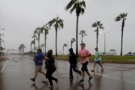 A group of people race across the street as winds from Hurricane Harvey escalated in Corpus Christi, Texas,