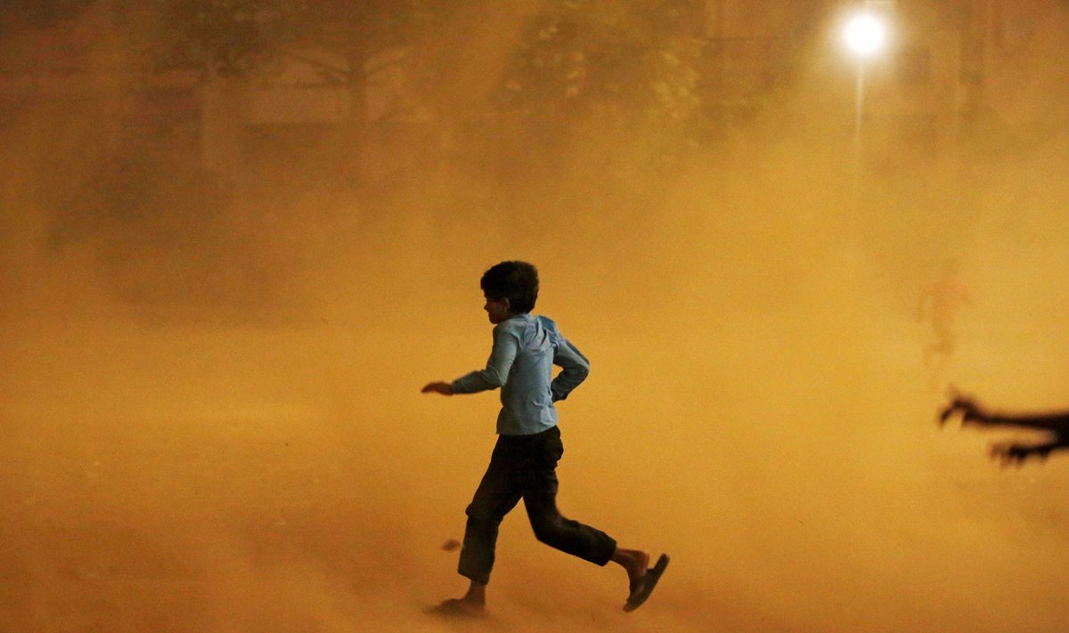 Väike poiss põgeneb New Delhis varju tuuletormi eest (Foto: REUTERS)
