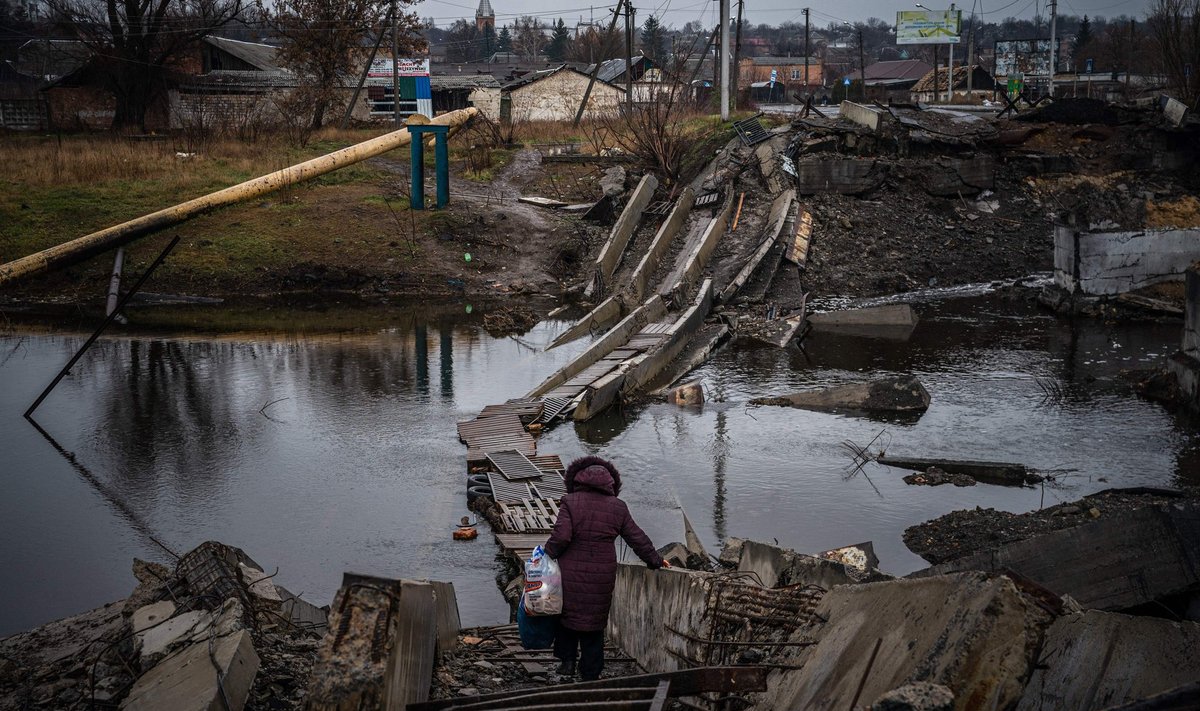 Женщина переходит через разрушенный мост в Бахмуте, Донецкая область, 6 января 2023 года.