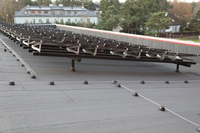 TalTechi Mäemaja päikesepaneelid on paigaldatud aluskonstruktsioonidele toetuvatele pollartitele. See tekitab küll marginaalsed külmasillad, kuid võimaldab korrektset katuse hooldust.  Hoonel on kõrged parapetid ja seepärast ei ole vaja ka turvavarustust.