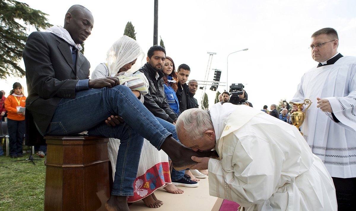 Pope Francis kisses the foot of a refugee during the foot-washing ritual at the Castelnuovo di Porto refugees center near Rome, Italy