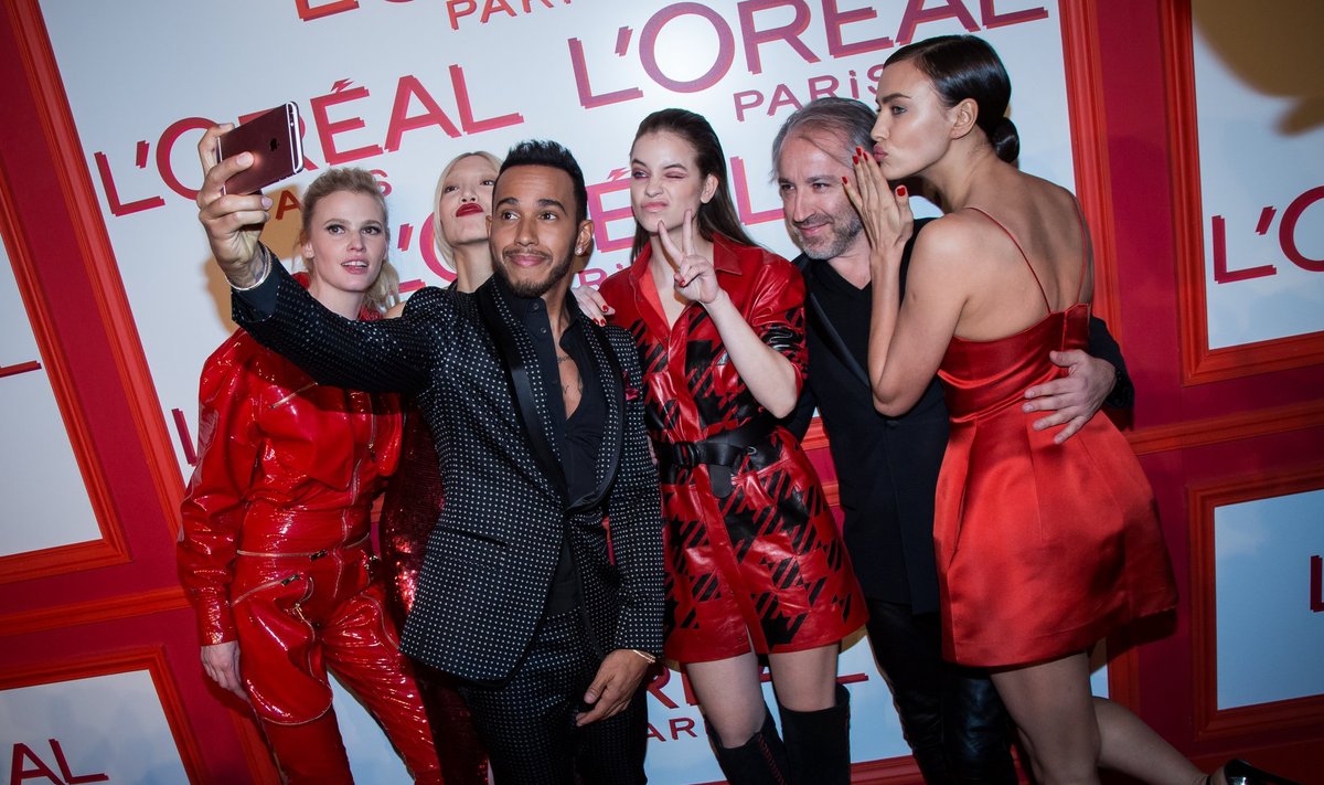 Lewis Hamilton (esiplaanil) poseerib koos modellidega. Seekord on ta näitsikutega pildile püütud Pariisis.