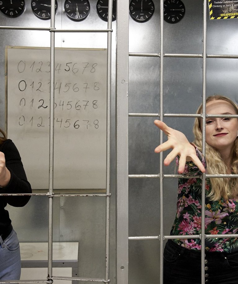 EscapeTartu mängujuht Ester Asso (vasakul) ja turundaja Angela Korela põgenemistoas, kus tuleb pangast põgeneda. Mida tähendavad numbrid seinal, miks on kellasid nii palju?