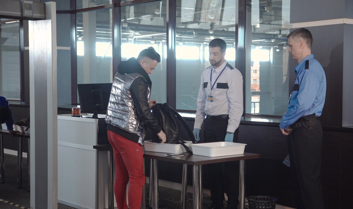 Lennujaama töötajad kontrollimas reisija kotti.
