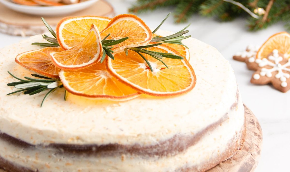 Apelsinikreemiga jõulutort, mis on kaunistatud kuivatatud apelsiniketastega.