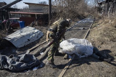 Ukraina territoriaalkaitseväe liige kahe vene sõduri surnukeha juures Irpinis
