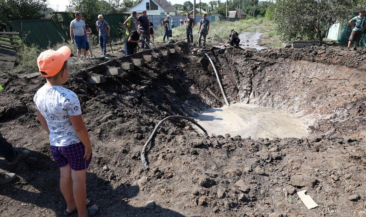 PÄRAST RÜNNAKUT: Kostjantõnivka küla sai raketitabamuse 15. juulil. Ukraina poiss vaatab, kuidas kommunaalameti töötajad taristu kahjustusi likvideerivad.
