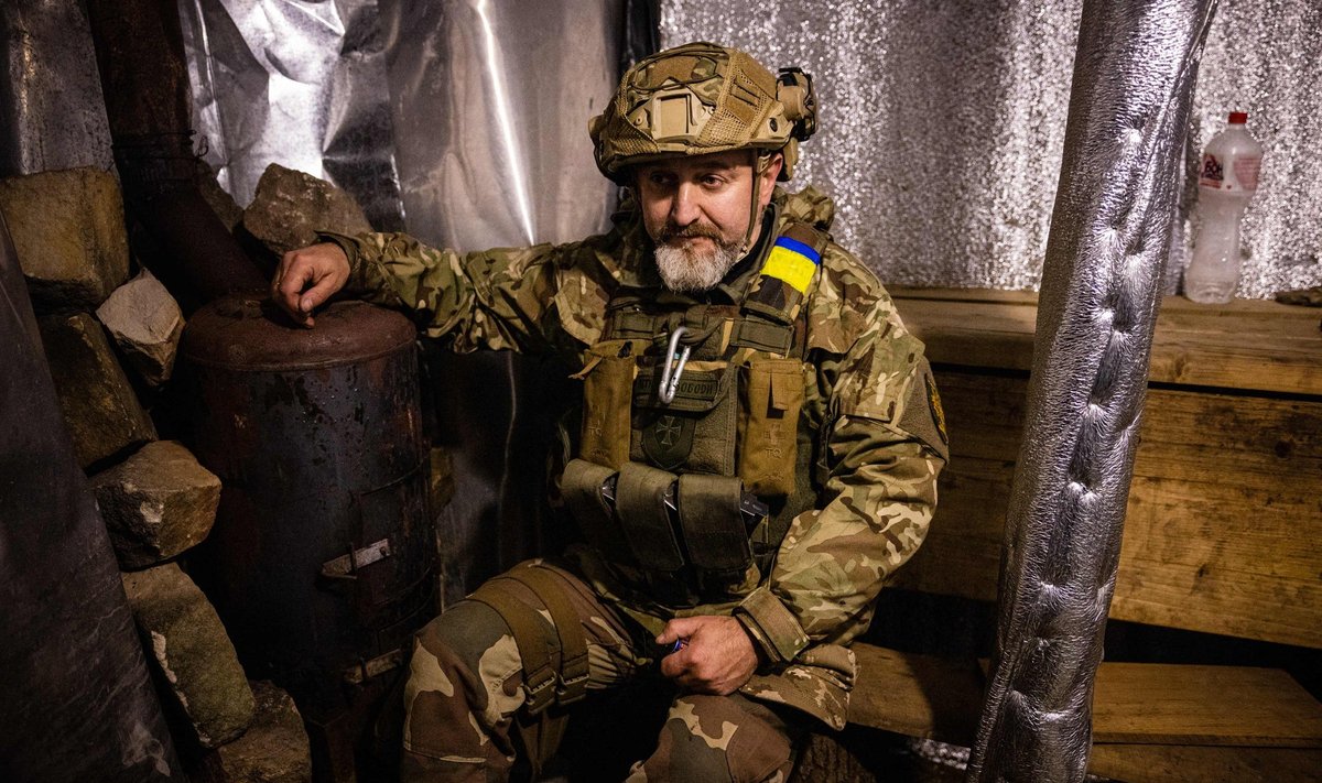 Ukraina sõdur omaehitatud saunahju kõrval istumas.