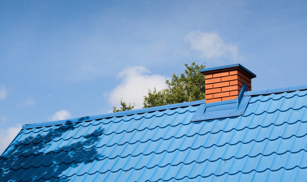 A,Blue,Tin,Roof,Along,With,A,Brick,Chimney,Against
