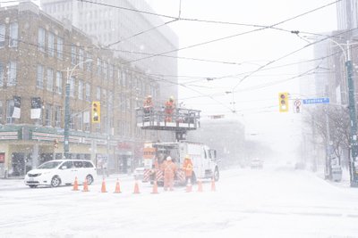 Töötajad parandavad Torontos lumetormi ajal tugeva tuule tõttu kahjustatud juhtmeid.
