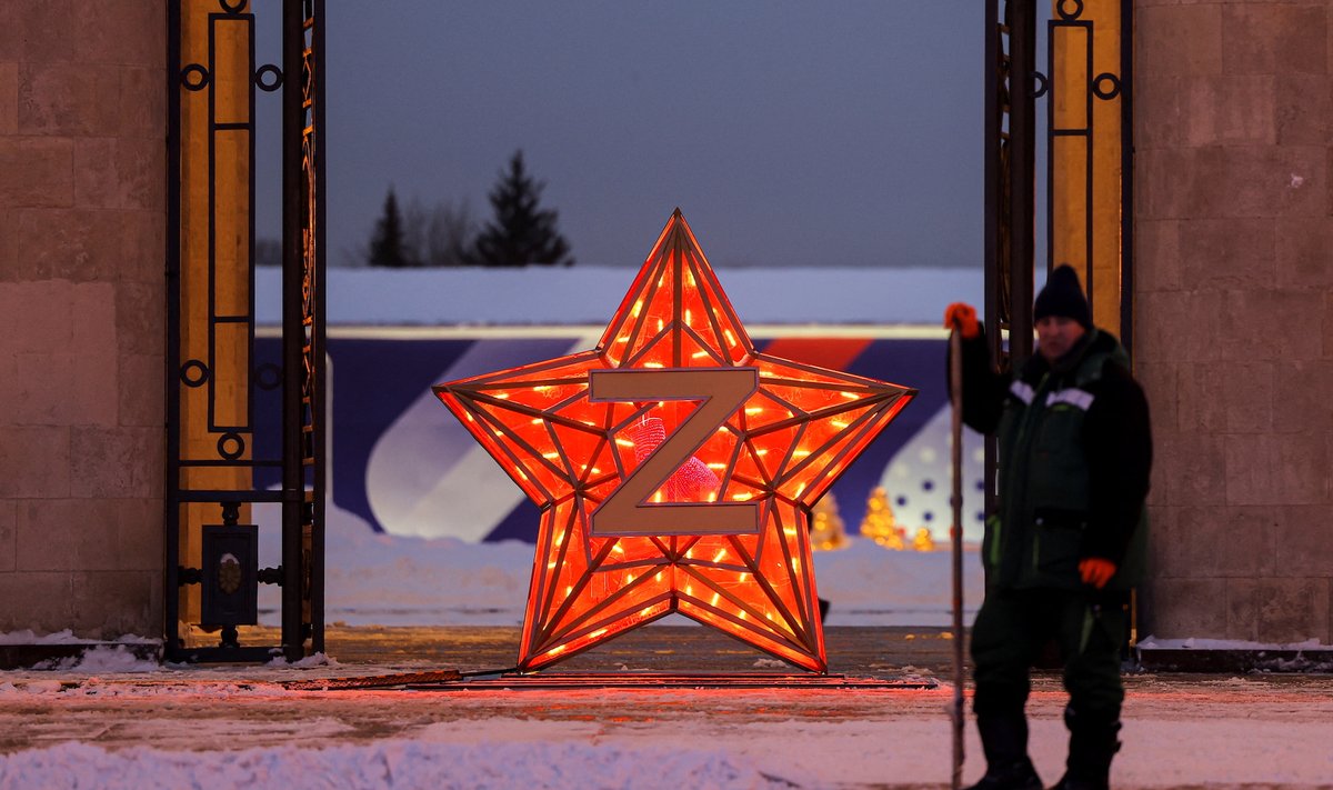 Дворник стоит возле звезды с символом Z в Москве