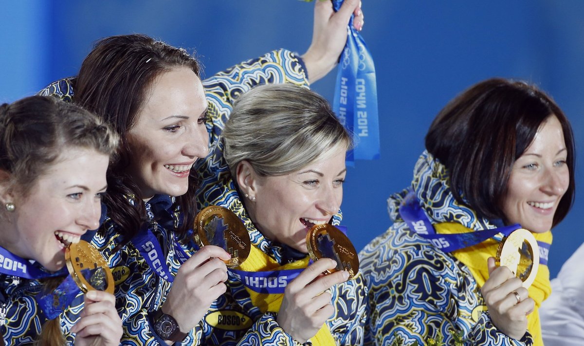 Gold medallists Ukraine's Dzhyma, Vita and Valj Semerenko and Pidhrushna pose during victory ceremony for women's biathlon 4 x 6km event at 2014 Sochi Winter Olympics