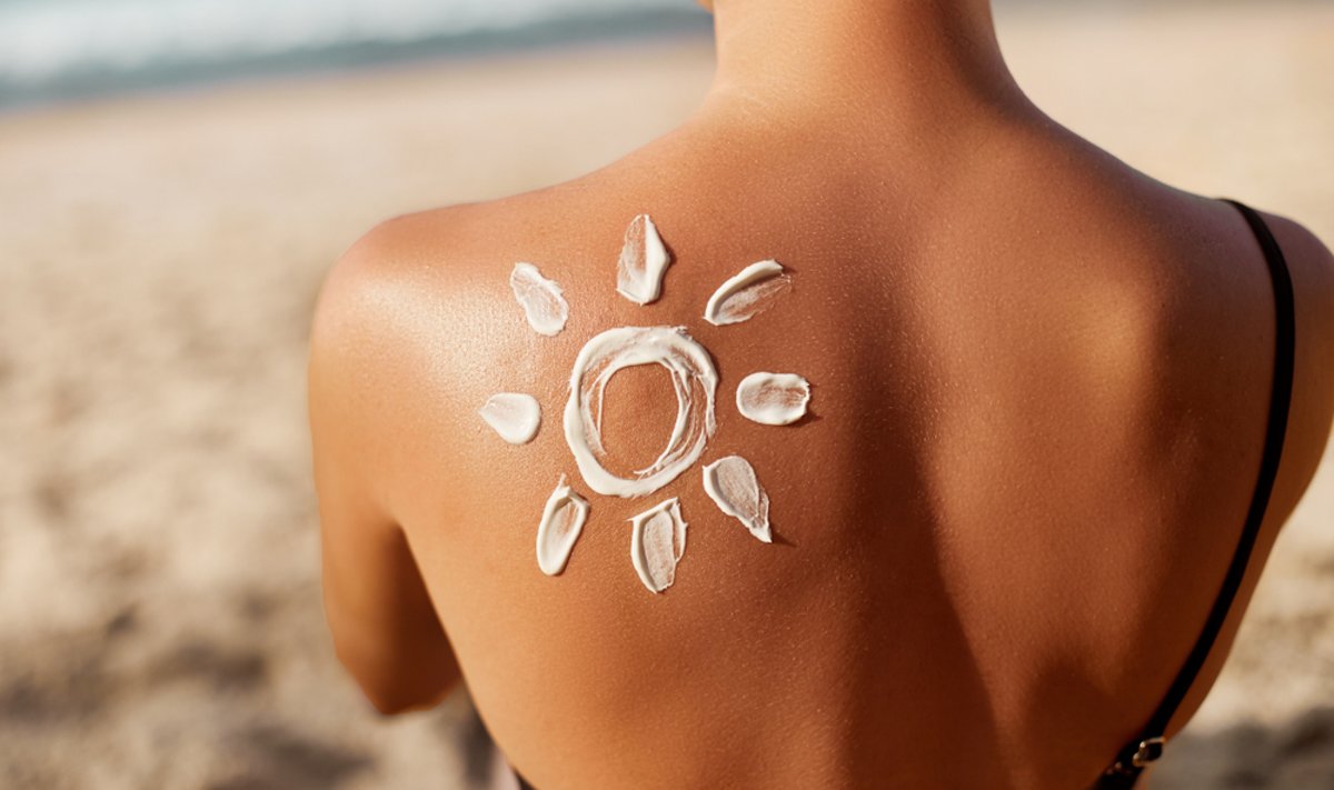 Woman,Applying,Sun,Cream,On,Tanned,Shoulder,In,Form,Of