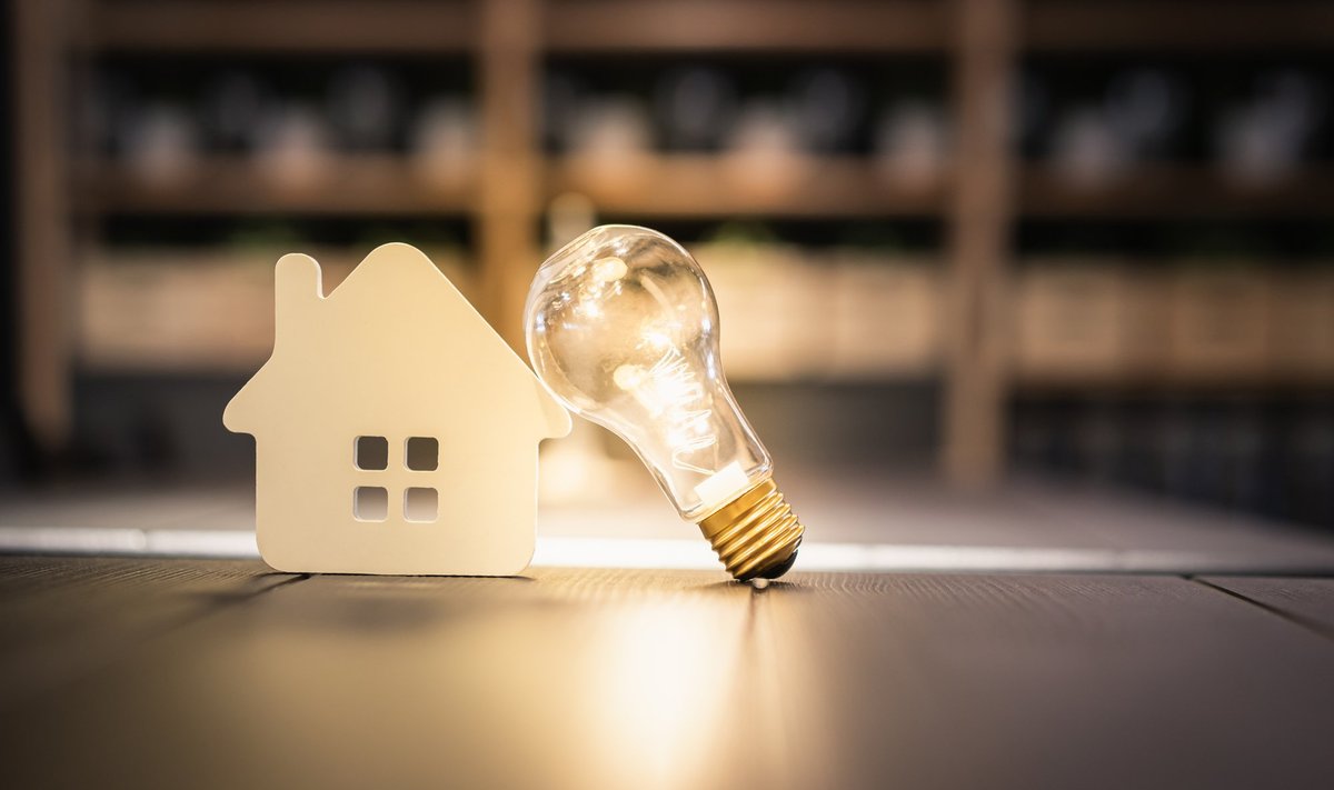Light,Bulb,With,Wood,House,On,The,Table,,A,Symbol
