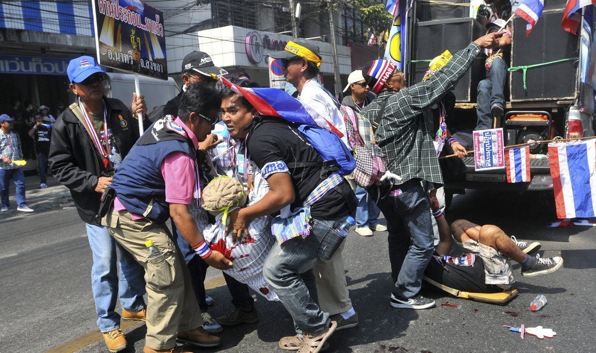 Anti-government protesters help a fellow protester injured in a grenade attack during a rally in Bangkok