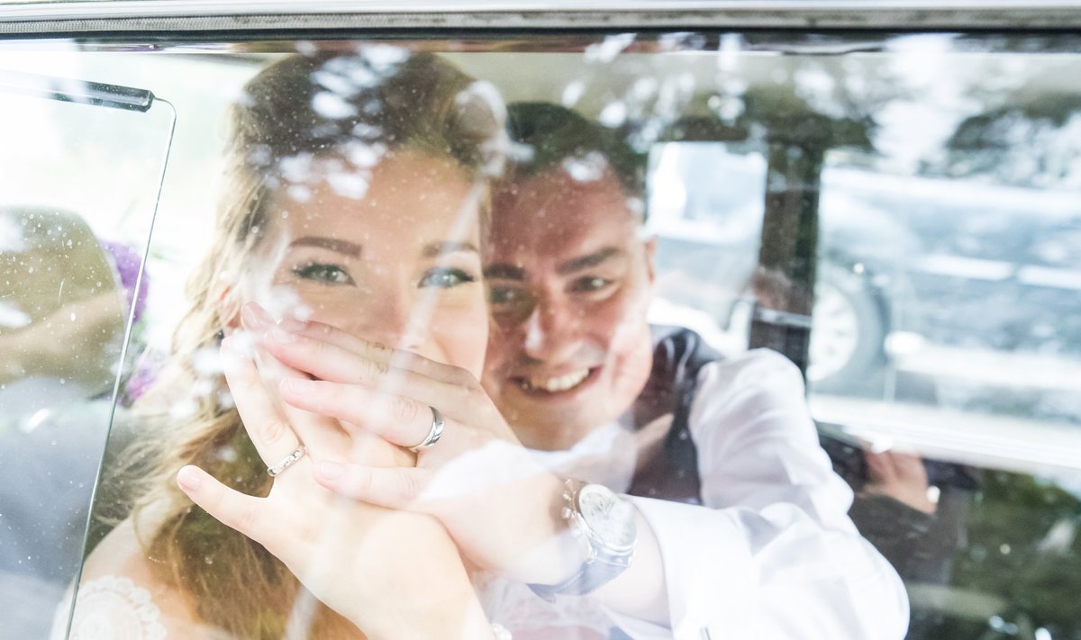 Luisa ja Taavi Rõivas näitavad pulmaautos olles esimest korda oma sõrmuseid.